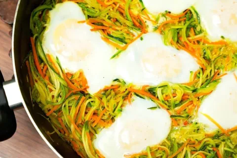 Almoço com ovos e legumes: abobrinha e cenoura refogadas par