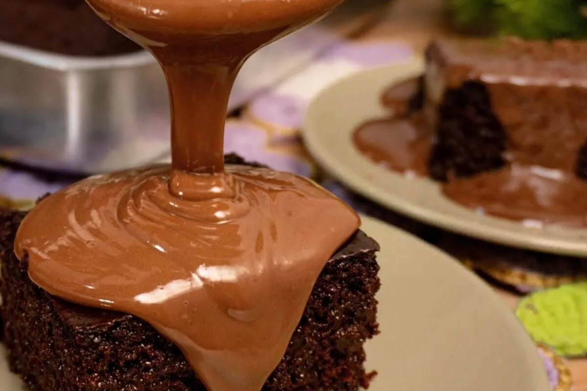 Bolo de chocolate molhadinho com cobertura cremosa e massa f