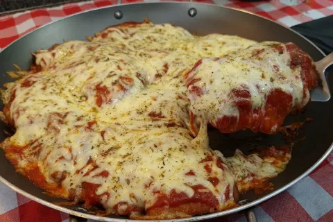 Frango à parmegiana suculento e com bastante queijo que não 