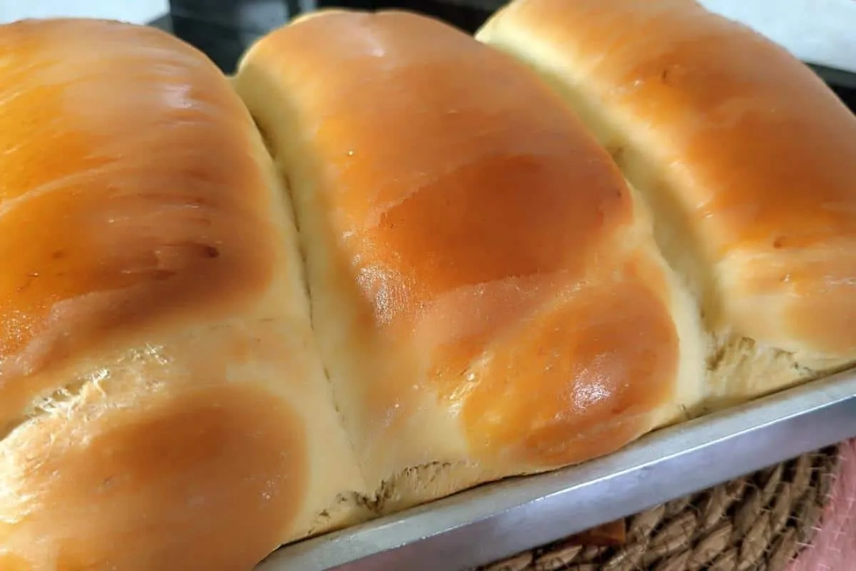 Pão caseiro fofinho para comer quentinho com manteiga e um c