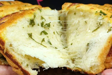 Pão de alho caseiro bem recheado e cremoso por dentro, para 