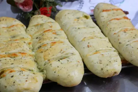 Pão de alho recheado com bastante queijo e creme temperado, 