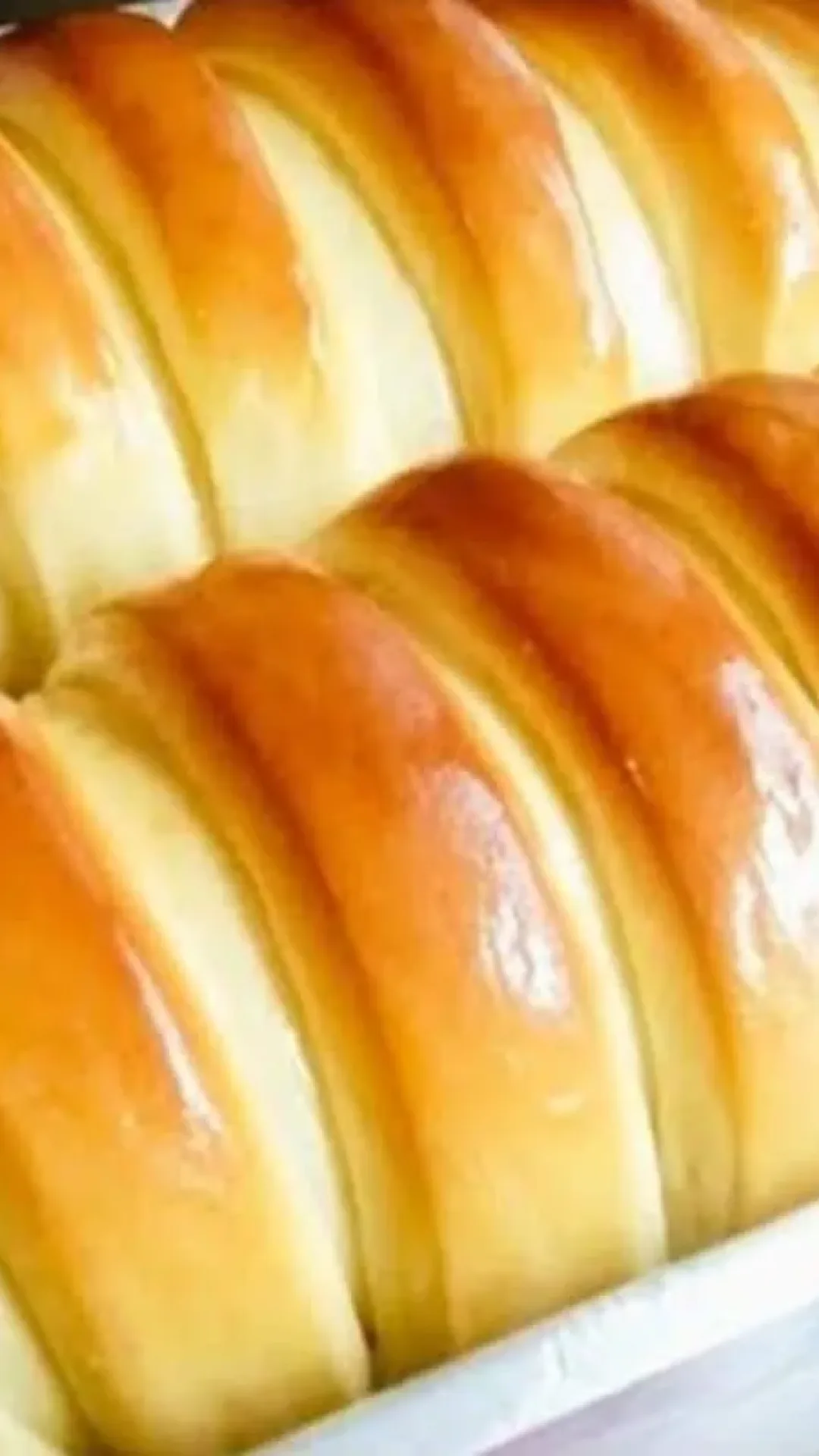 Pão caseiro fofinho que já sai do forno fatiado para a hora do café