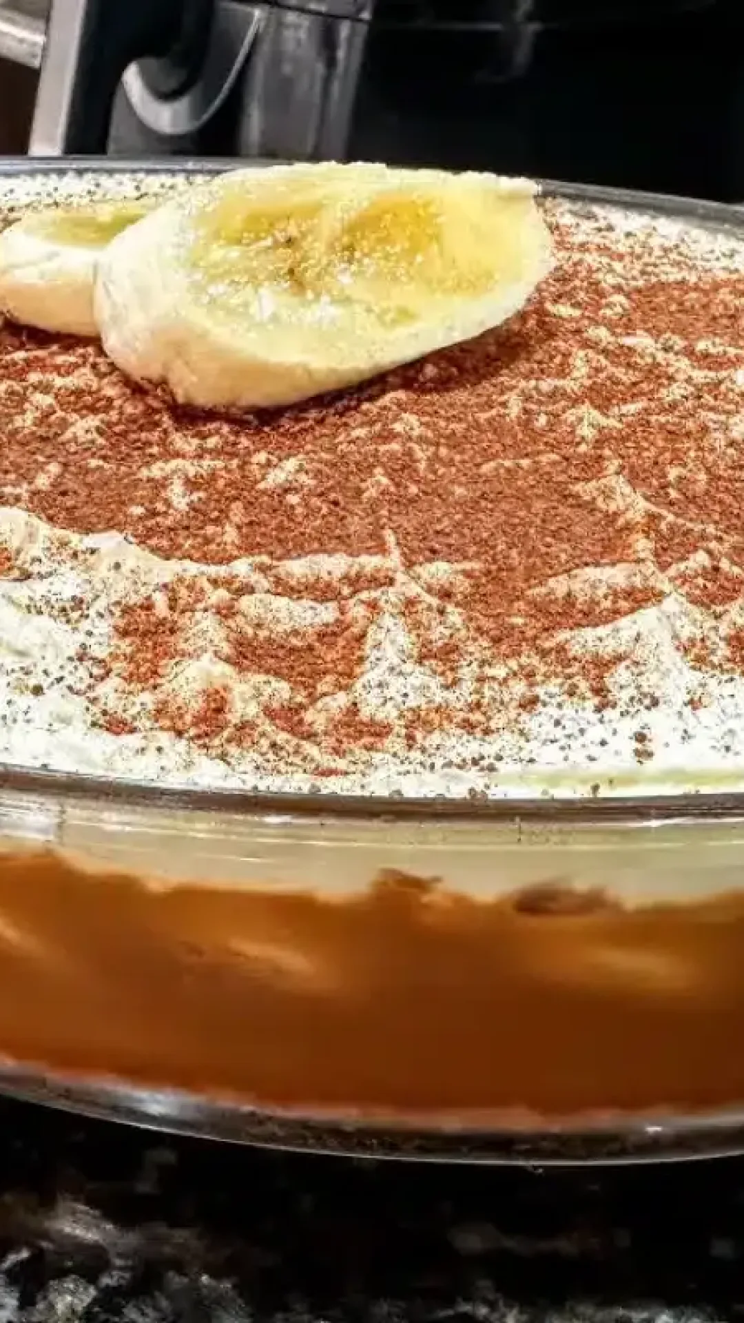 Torta banoffee montada na travessa com camadas generosas de doce de leite e banana