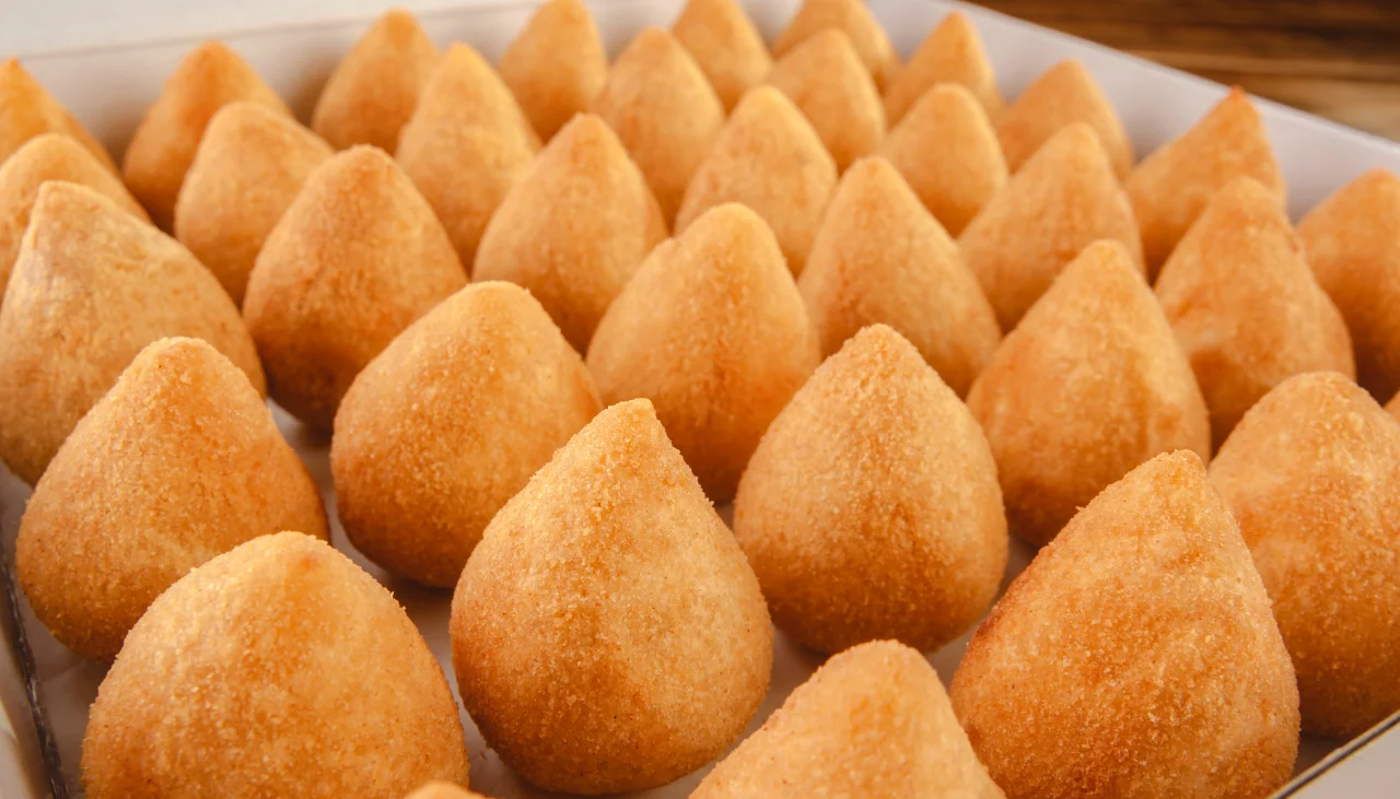 Muitas coxinhas servidas em uma bandeja.