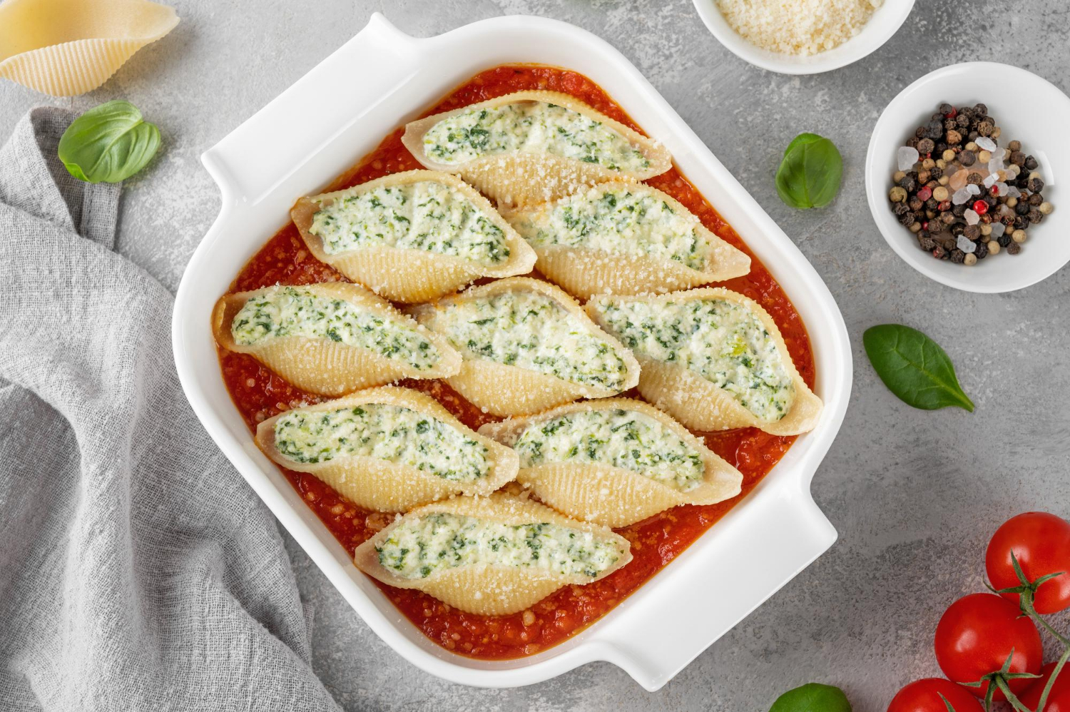 O conchiglione recheado é uma opção perfeita para quem busca um prato saboroso e sofisticado. Seu formato de concha permite recheios variados, tornando-o versátil para diferentes ocasiões. Como surgiu o Conchiglione? O conchiglione tem origem italiana, sendo uma das diversas variedades de massas desenvolvidas na região da Campânia. Seu nome vem do italiano "conchiglia", que significa concha, remetendo ao seu formato característico. Tradicionalmente, ele é servido recheado e gratinado, com molhos que variam entre tomate e bechamel. Quantas Calorias tem o Conchiglione? As calorias do conchiglione variam conforme o recheio e o molho utilizado. Em média, uma porção de 200g de conchiglione recheado com queijo e molho de tomate possui cerca de 350 a 450 calorias. Informações nutricionais da receita e rendimento Tipo de receita: Massa recheada Tempo de preparo: 30 minutos Tempo de forno: 20 minutos Tempo total: 50 minutos Rendimento: 4 porções Calorias por porção: Aproximadamente 400 kcal Ingredientes 300g de conchiglione (massa em formato de concha) 250g de ricota (para um recheio cremoso) 100g de espinafre cozido e picado (opcional, para um toque mais saudável) 200g de queijo muçarela ralado (para gratinar) 50g de parmesão ralado (para um sabor extra) 1 ovo (para dar liga ao recheio) 500ml de molho de tomate (para cobrir e deixar suculento) 2 colheres de sopa de azeite de oliva (para refogar) 2 dentes de alho picados (para temperar) Sal e pimenta-do-reino a gosto (para ajustar o sabor) Equipamentos Necessários Panela grande para cozinhar a massa Assadeira para levar ao forno Frigideira para refogar o espinafre (se utilizar) Tigela para misturar o recheio Modo de Preparo 1. Cozinhando a Massa Ferva água com sal e cozinhe o conchiglione até ficar al dente. Escorra e reserve. 2. Preparando o Recheio Misture a ricota, o espinafre, o ovo, metade da muçarela e tempere com sal e pimenta. 3. Montagem do Prato Recheie cada conchiglione com a mistura de ricota e espinafre. Distribua-os em uma assadeira coberta com molho de tomate. 4. Finalização e Forno Cubra com mais molho de tomate, polvilhe muçarela e parmesão. Leve ao forno preaquecido a 180ºC por 20 minutos até gratinar. Dicas Extras Experimente outros recheios como frango com catupiry ou carne moída com requeijão. Para um toque gourmet, adicione nozes picadas ao recheio de ricota. Sugestões de Acompanhamento O conchiglione recheado combina perfeitamente com: Salada verde com molho balsâmico Pão italiano crocante Vinho tinto leve, como Merlot ou Pinot Noir Como Armazenar Geladeira: Armazene em recipiente fechado por até 3 dias. Freezer: Congele por até 2 meses, descongelando na geladeira antes de reaquecer. Reaquecimento: Use o forno a 180ºC por 15 minutos ou micro-ondas por 2 minutos. Considerações Finais O conchiglione recheado é uma receita fácil, saborosa e perfeita para impressionar em qualquer ocasião. Experimente e surpreenda-se! FAQs Posso usar outro tipo de queijo? Sim! Cottage, cream cheese ou queijo minas também funcionam bem. Qual é o melhor molho para acompanhar? Molho de tomate é o mais usado, mas molho branco também é uma ótima opção. Posso fazer a receita sem forno? Sim! Basta aquecer no micro-ondas até o queijo derreter. O conchiglione pode ser feito com recheio vegano? Sim! Substitua os queijos por tofu temperado e use molho de castanhas. Qual vinho harmoniza melhor com esse prato? Tintos leves como Merlot ou Chianti combinam muito bem.